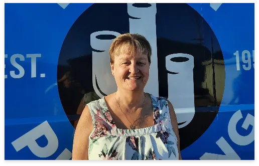 Bonnie, New Construction Warranty Manager, in front of a Tucson Plumbing van