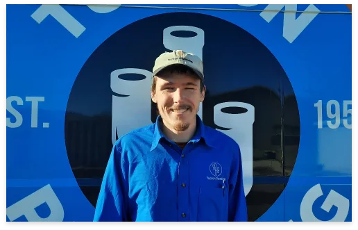 Chris, Plumbing Technician, in front of a Tucson Plumbing van