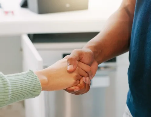 A technician and a homeowner shaking hands