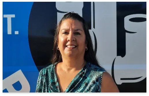 Lisa, Service Office Manager, in front of a Tucson Plumbing van